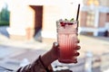 Refreshing pomegranate lemonade in girl`s hand.