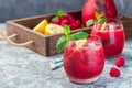 Refreshing raspberry, lemon and mint lemonade with sparkling water in a glass, horizontal, copy space