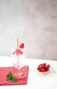 Refreshing raspberry lemonade in a glass with a cocktail straw is on a red napkin and on a white table. Royalty Free Stock Photo