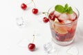 Refreshing red cocktail with sparkling water and ice garnished with a lime and cherry Royalty Free Stock Photo