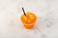 Refreshing Slushie drink, top view. Orange Granizado in disposable plastic cup. Sweet citrus Shaved ice. Take away food and drink Royalty Free Stock Photo