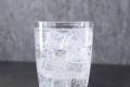 Refreshing soda water with ice cubes in glass on blurred background, closeup Royalty Free Stock Photo