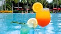 Refreshing summer alcoholic fruit cocktails with ice and citrus fruits poolside