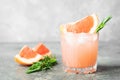 Refreshing summer cocktail grapefruit rosemary juice and ice in glass goblet on a gray concrete background. Drink detox. Royalty Free Stock Photo