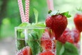Refreshing summer cold drinks Strawberry with mint in glass on wooden table, outdoor.