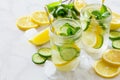 Refreshing summer drink with lemon and cucumber on a background of stone.