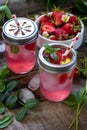 Refreshing Summer drink. Lemonade with fresh strawberries, ice and lemons on a rustic wooden table. Royalty Free Stock Photo