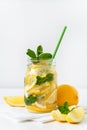 Refreshing summer drink. Lemonade in a glass jar with green paper straw, lemon slices and mint.