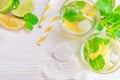 Refreshing summer drink mojito with lime, lemon and mint, with ice cubes on white wooden background. Flat-lay, top view Royalty Free Stock Photo