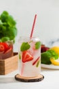 A refreshing summer drink with strawberries, lemon and mint in a glass on a light background. Strawberry lemonade Royalty Free Stock Photo