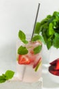 A refreshing summer drink with strawberries, lime and mint in a glass. Ice-cold summer lemonade. Royalty Free Stock Photo