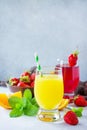 Refreshing summer drinks assortment. Orange juice, strawberry juice, fresh oranges and strawberries Royalty Free Stock Photo