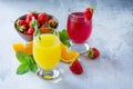 Refreshing summer drinks assortment. Orange juice, strawberry juice, fresh oranges and strawberries Royalty Free Stock Photo