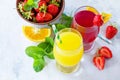 Refreshing summer drinks assortment. Orange juice, strawberry juice, fresh oranges and strawberries on a gray stone or slate Royalty Free Stock Photo