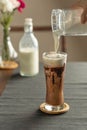 Refreshing summer drinks or beverages, chocolate cocoa latte with chocolate sauce and cold foam milk on top in a tall glass