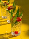 Refreshing summer drinks in crystal glasses green leaves raspberry on yellow tile background Sweet cold natural cocktail Royalty Free Stock Photo