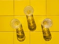 Refreshing summer drinks in crystal glasses on yellow bar tile background with harsh shadows Sweet cold natural cocktail