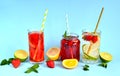 Refreshing summer drinks of lemon, lime, strawberry, orange, mint on a blue background. Detox, healthy eating, fitness drinks. Royalty Free Stock Photo