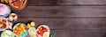 Refreshing summer food corner border on a dark wood banner background