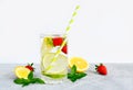 Refreshing summer lemonade in a glass cup from lemon, lime, strawberry, orange, mint on a white background. Flax drinks