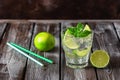 Refreshing summer mojito lemonade in a glass. Cold drink with lime  mint and ice. Wooden dark old table. Selective focus Royalty Free Stock Photo