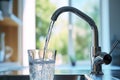 Refreshing tap water flowing into glass, clean drinking water in a modern kitchen environment Royalty Free Stock Photo