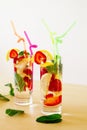 Refreshing vibrant summer drinks with lemon, strawberry and mint on the wooden table