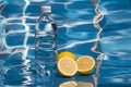 Refreshing water in plastic bottle with lemon slices on shiny surface, blue background Royalty Free Stock Photo