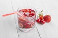 Refreshing water from red berries in a glass on wooden table. Homemade tasty and healthy drinks Royalty Free Stock Photo