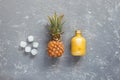 Refreshing yellow smoothie with pineapple and ice cubes on gray wooden table, top view