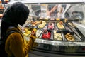 Refrigerated display case with a large assortment of soft ice cream in an Italian store