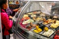 Refrigerated display case with a large assortment of soft ice cream in an Italian store