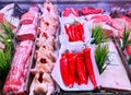 Refrigerated display case with pork neck, farm chicken, marbled beef and sweet long pepper in the restaurant kitchen