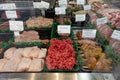 refrigerated display showcases a variety of raw, fresh meats for customers to choose from.