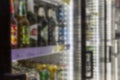 Refrigerated glass showcases with alcoholic beverages in the store. Blurred