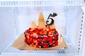 in refrigerator a birthday cake decorated with berries and a number five.