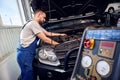 Refueling the air conditioner. A mechanic pumps freon into the air conditioning system at a car service Royalty Free Stock Photo