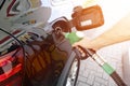 Refueling the car at a gas station fuel pump. Man driver hand refilling and pumping gasoline oil the car with fuel at he refuel Royalty Free Stock Photo