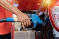 Refueling the car at a gas station fuel pump. Man driver hand refilling and pumping gasoline oil the car with fuel at he refuel Royalty Free Stock Photo