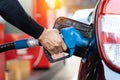 Refueling the car at a gas station fuel pump. Man driver hand refilling and pumping gasoline oil the car with fuel at he refuel Royalty Free Stock Photo