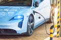 Refueling for cars e-mobility, with headlights on and blue light. Charging an electric car at hybrid engine gasoline and