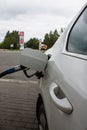 refueling gun inserted into the open hatch of the gas tank of the car close-up Royalty Free Stock Photo