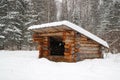 A refuge for partisans in the forest in winter, a structure of logs with a roof Royalty Free Stock Photo