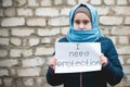 Refugee girl with an inscription on a white sheet