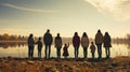 Refugees. Back view silhouette of a group of people standing on a lake shore with children