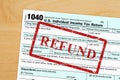 Refund message with US federal 1040 tax return form on a desk