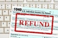 Refund message with US federal 1040 tax return form on a keyboard
