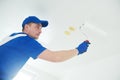 Refurbishment. Painter painting ceiling with paint roller