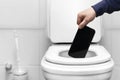 refusal of the phone. a man& x27;s hand throws the phone into the toilet because of a breakdown or refusal of calls and Royalty Free Stock Photo