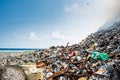 Refuse at the garbage dump full of smoke, litter, plastic bottles,rubbish and trash at tropical island Royalty Free Stock Photo